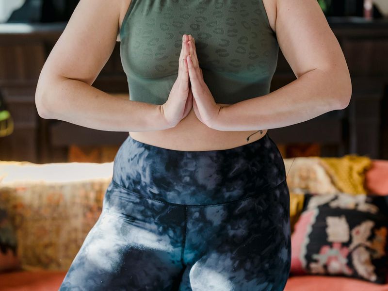 Person holding a balancing yoga pose in a minimalist room.